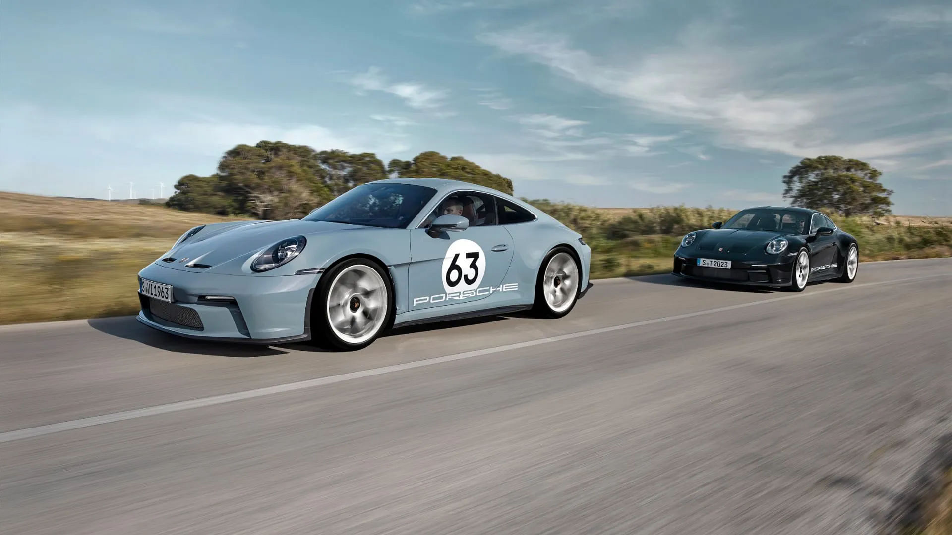 2 Porsche 911 S/Ts driving down a road