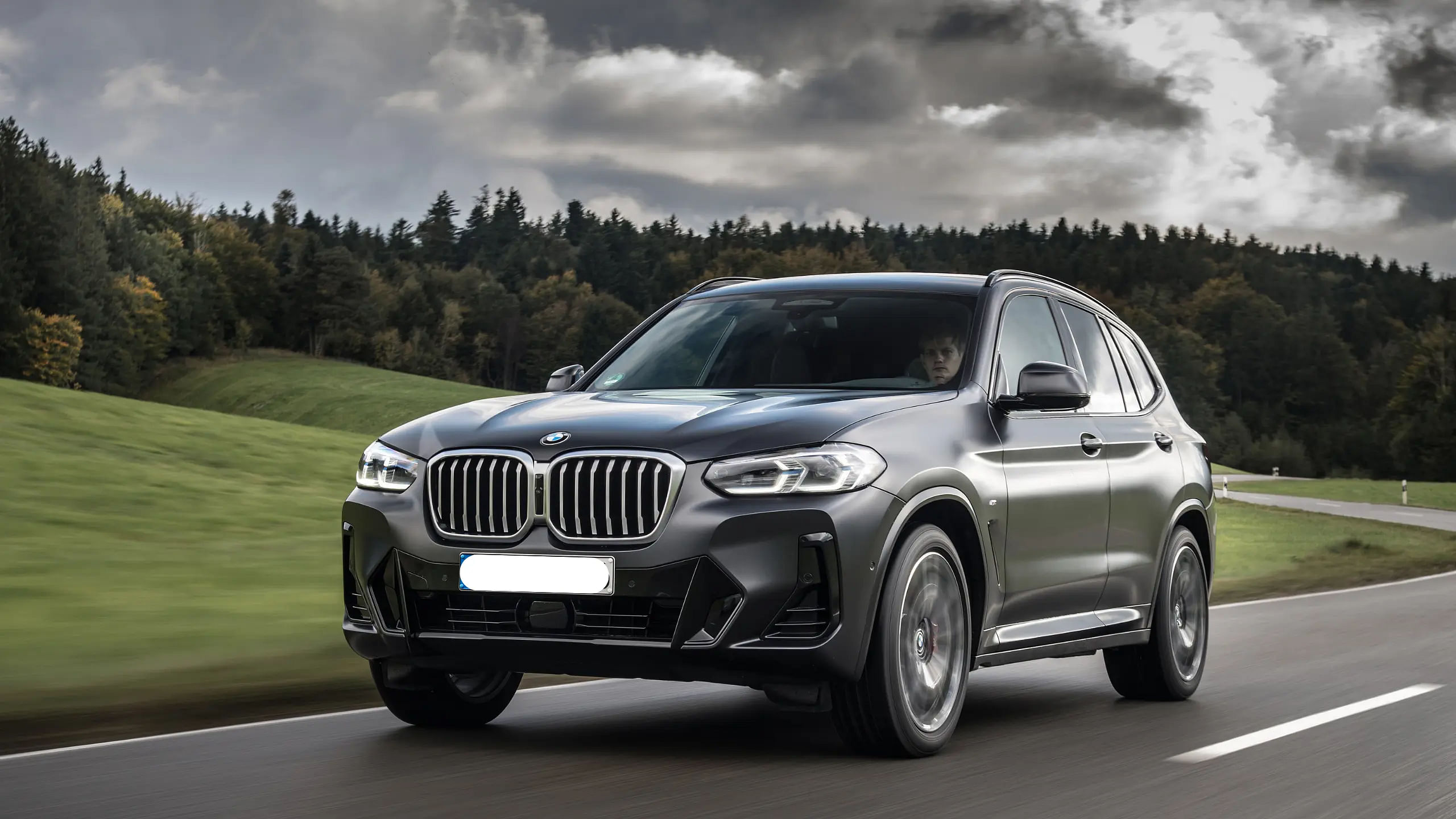 2024 BMW X3 driving down a road