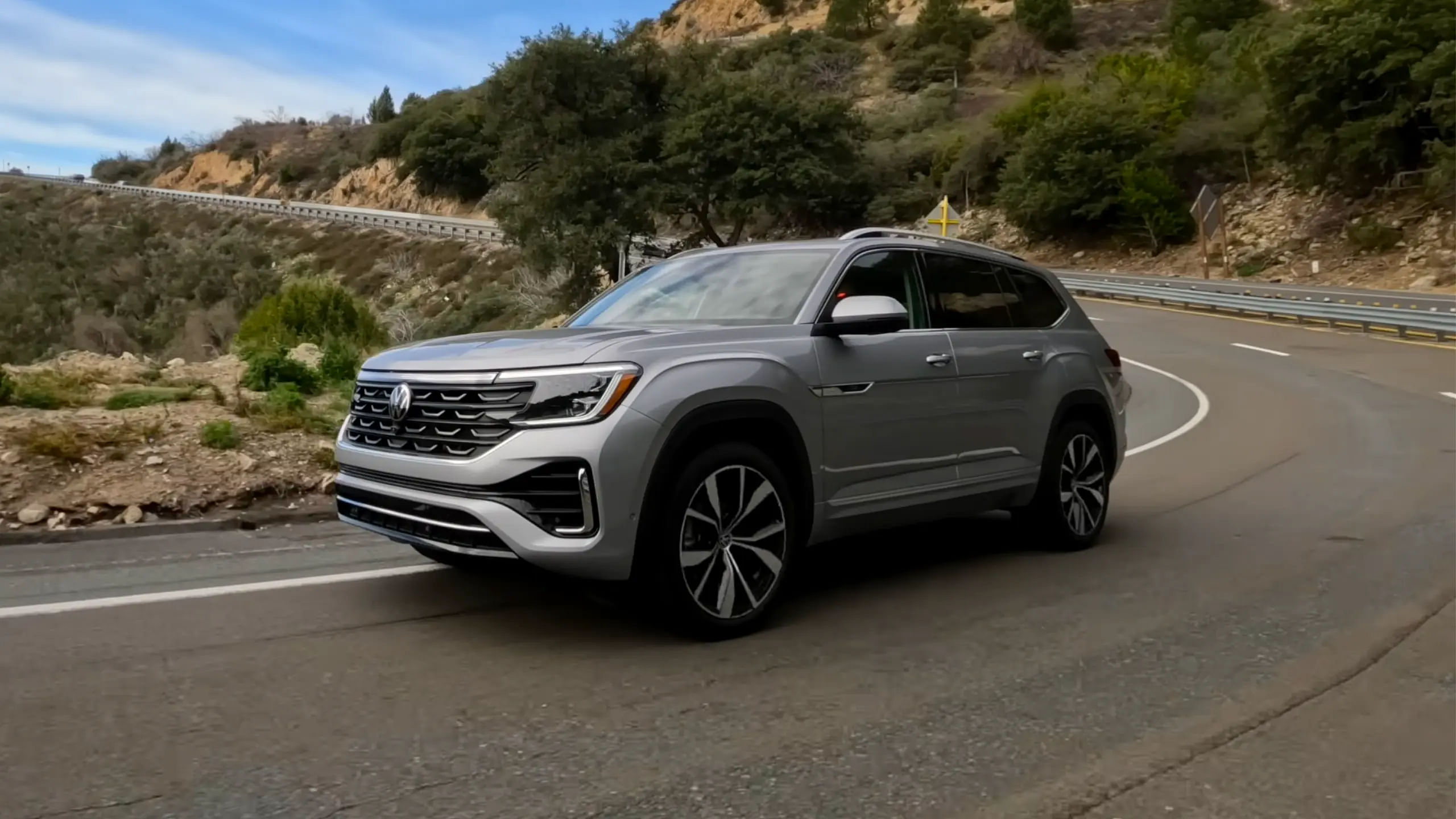 side view of 2024 Volkswagen Atlas driving down a road 