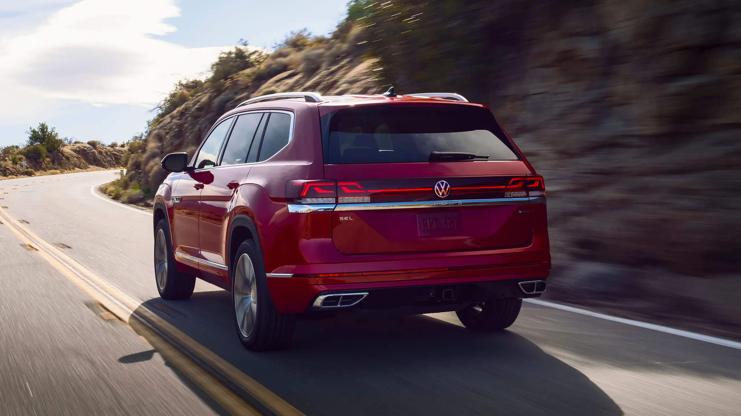 rear view of 2024 Volkswagen Atlas driving down a road