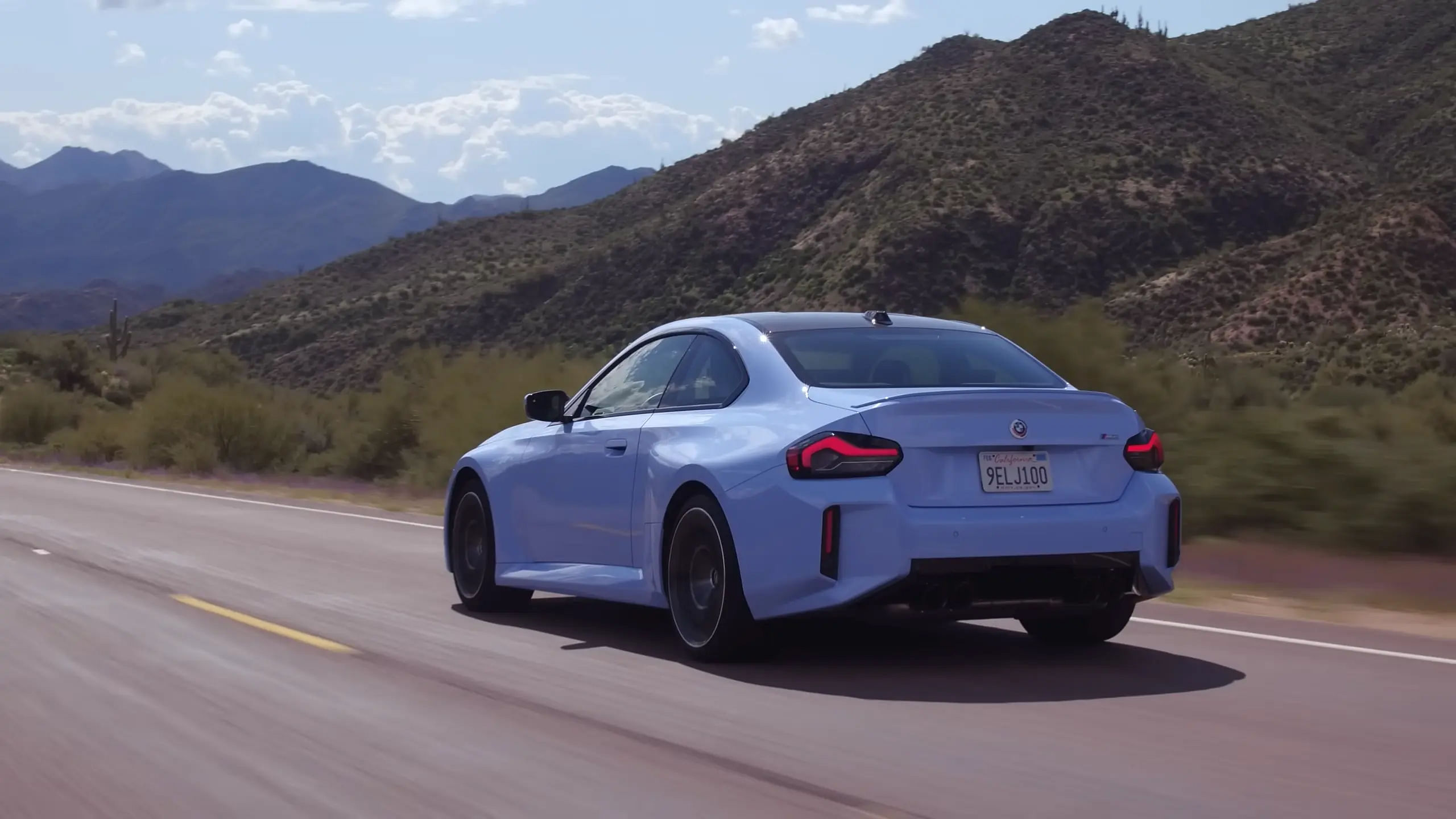 rear view of the 2024 BMW M2 driving 