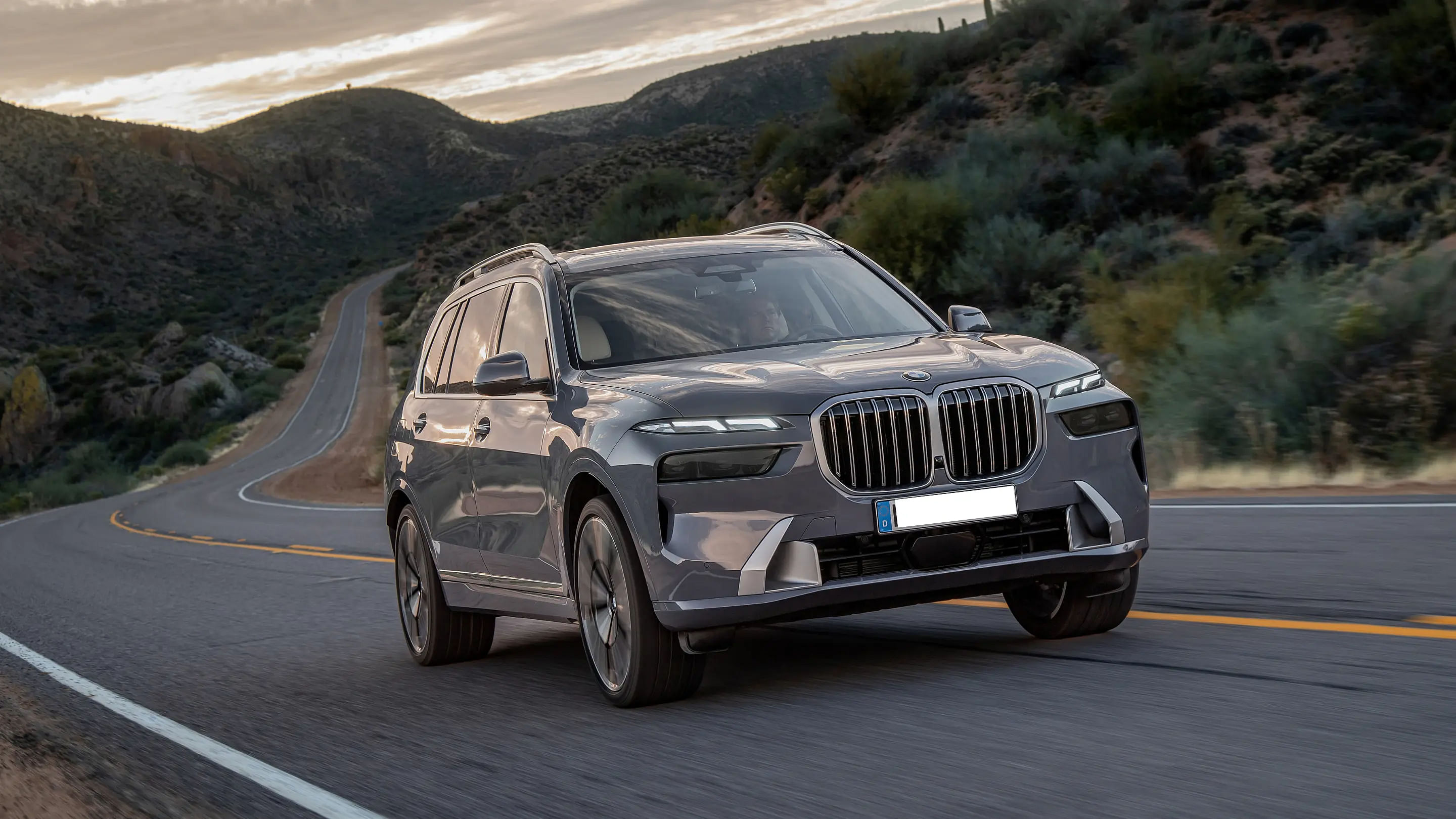 front view 2024 BMW X7 driving down a road